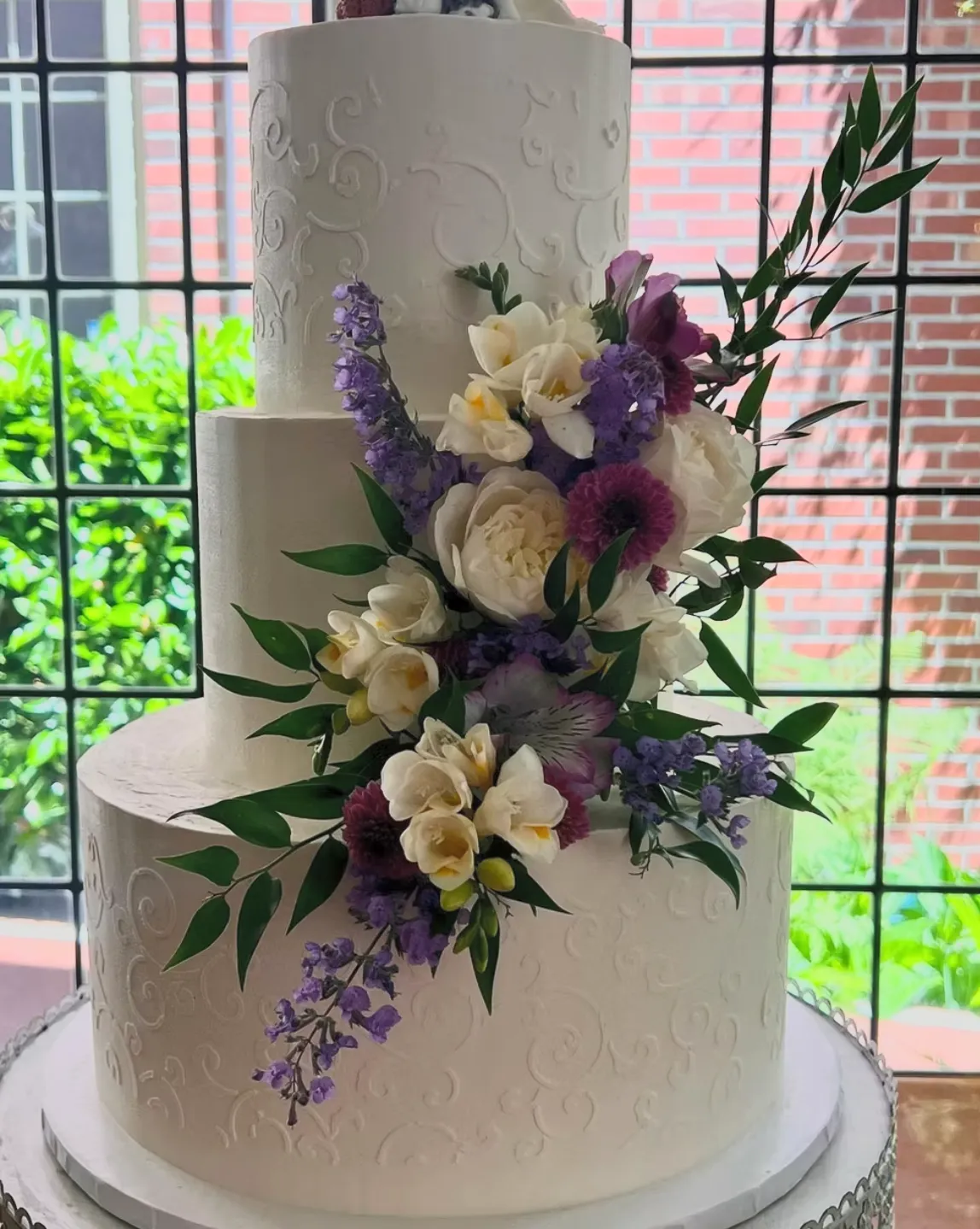 slice-of-heaven-bellingham-wedding-cake-three-tier-scrollwork-purple-white-flowers image